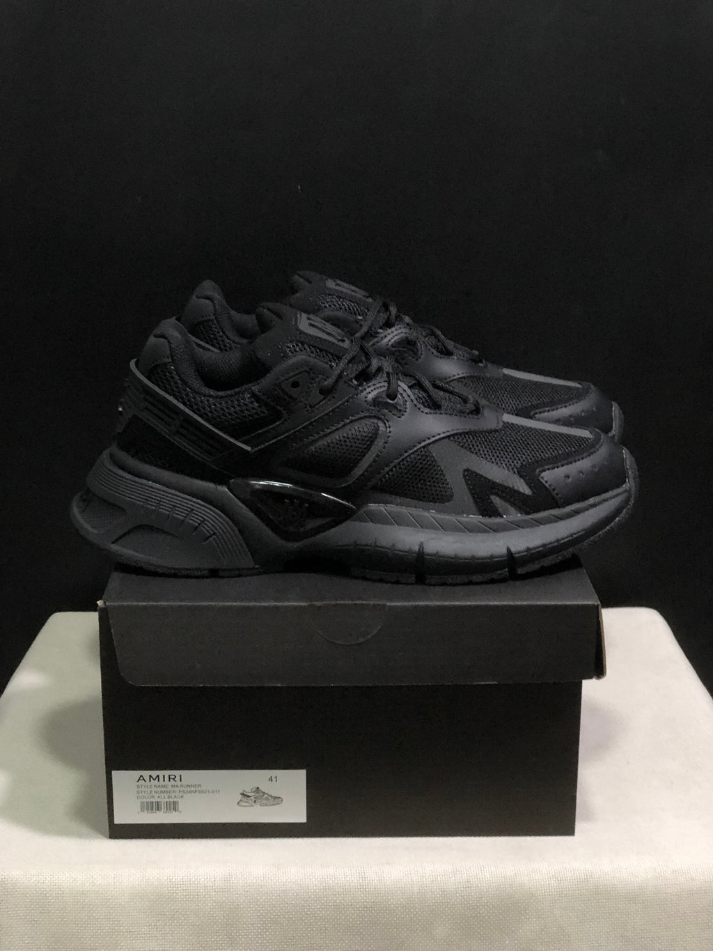 Side-front view of black AMIRI MA Runner sneakers with layered panels and chunky outsoles.