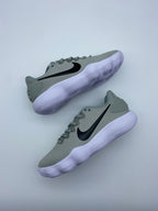 Pair of grey Nike low-top sneakers with black Swoosh logos and white ridged soles