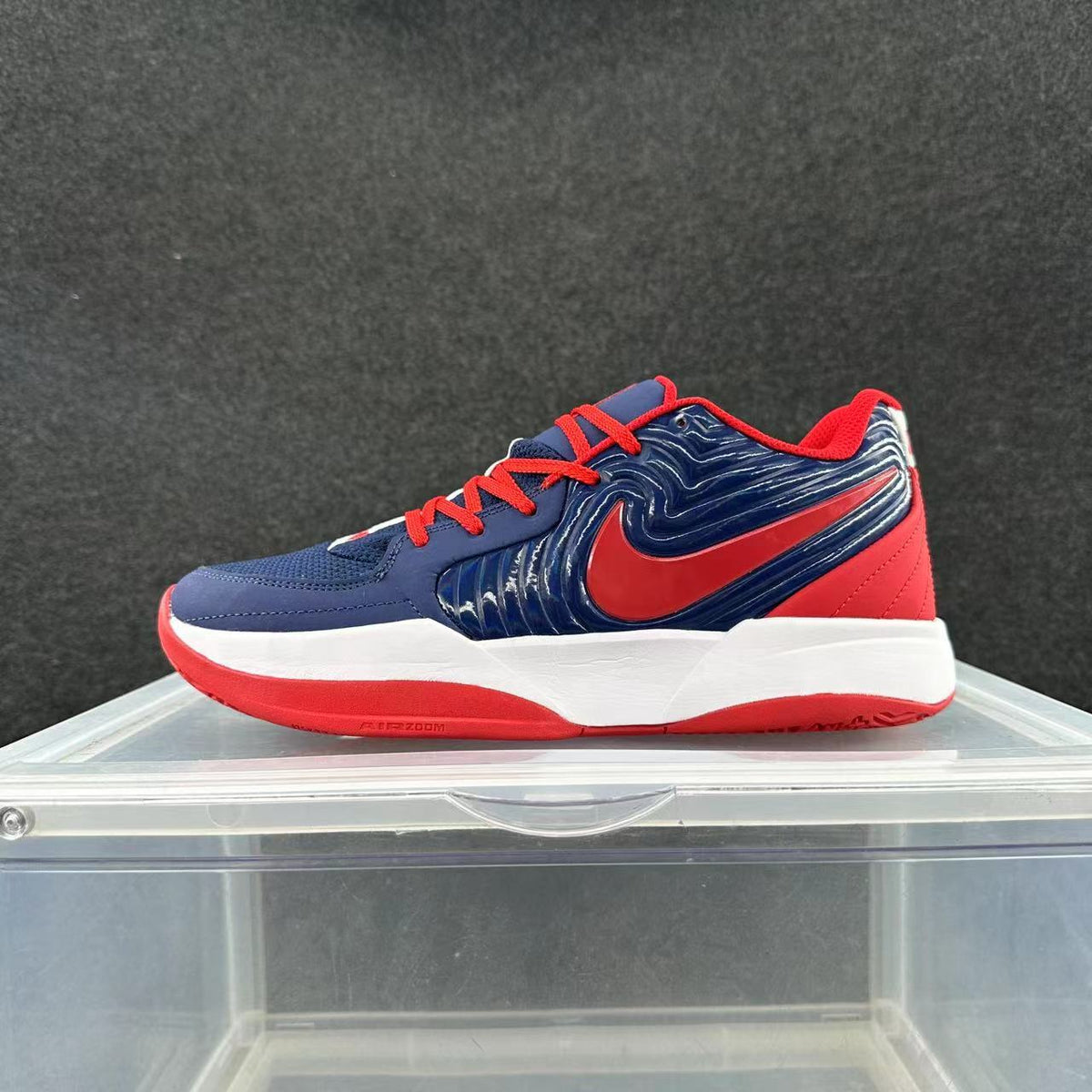 Side view of a navy, white, and red Nike low-top sneaker with a red Swoosh and AIR ZOOM outsole marking
