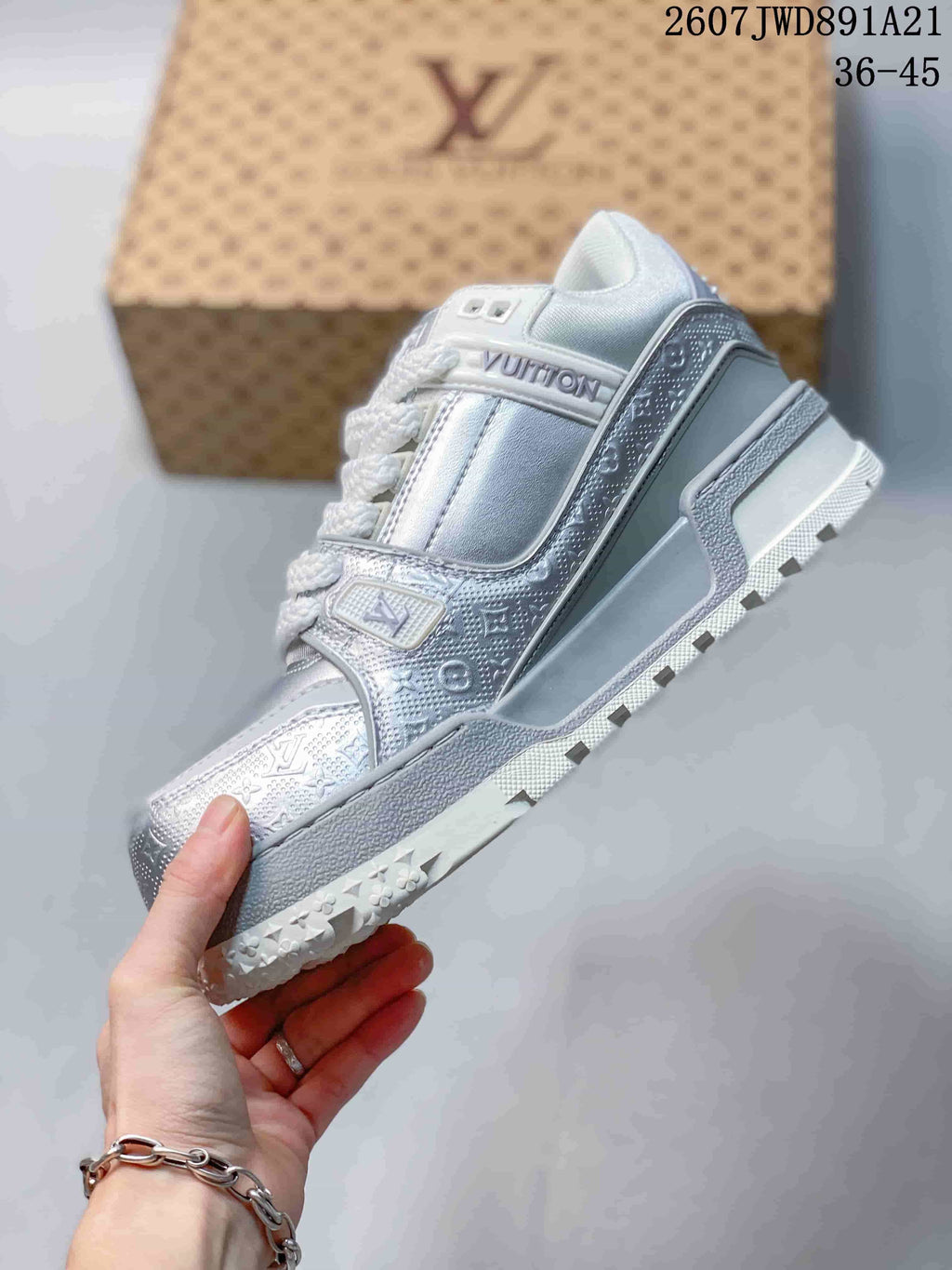 Side view of the silver and white sneaker showing the patterned panels, lace-up design, and layered outsole.