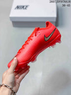 Side view of a red Nike Mercurial soccer cleat with black-and-gold swoosh detailing and molded studs.