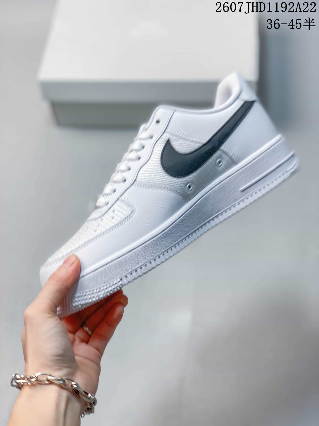 Side view showing the black Swoosh, white upper, and layered sole.