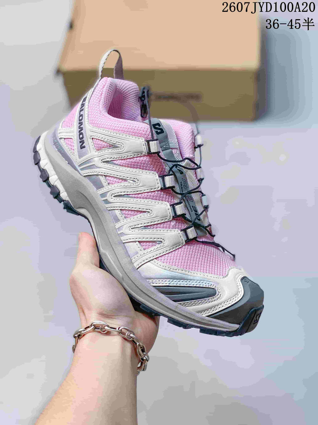 Salomon XA PRO 3D trail shoe in a pink, white and gray colorway with a cord-style lacing system.