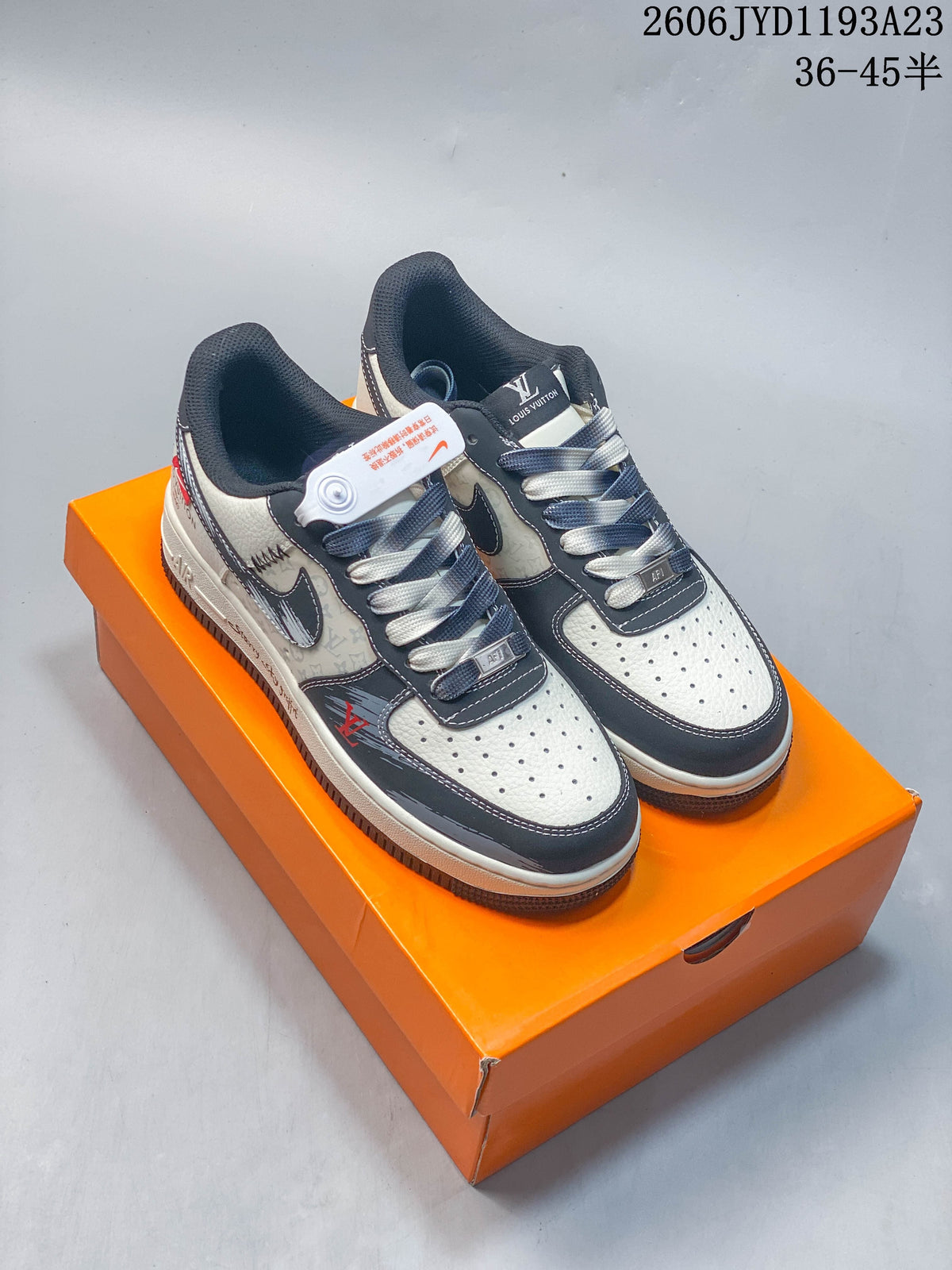Pair of cream and charcoal Nike Air Force 1 Low-style custom sneakers on an orange box