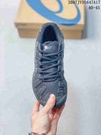 Top view of a dark lace-up ASICS tennis shoe showing the mesh-like tongue and textured toe area; image text shows 2607JYD1647A17 and 40–45.