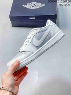 Side view of a white and light-grey low-top sneaker with a swoosh and panel graphics