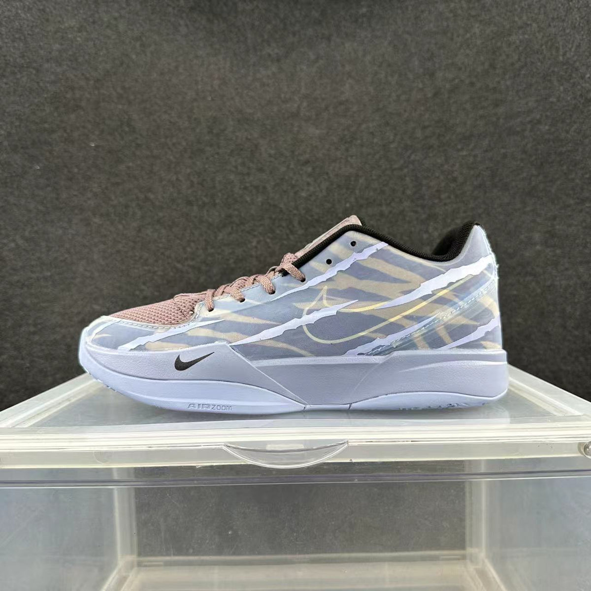Side view of a blue, white, and pink Nike low-top basketball sneaker with patterned panels and a white sole.