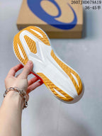 Underside view of the shoe showing the white sole structure and yellow patterned outsole sections.