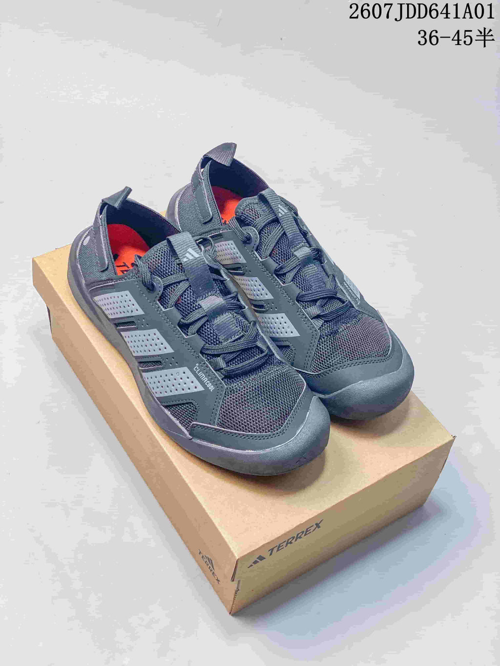 Pair of gray Adidas Terrex-style lace-up outdoor sneakers on a box, shown from above at an angle.