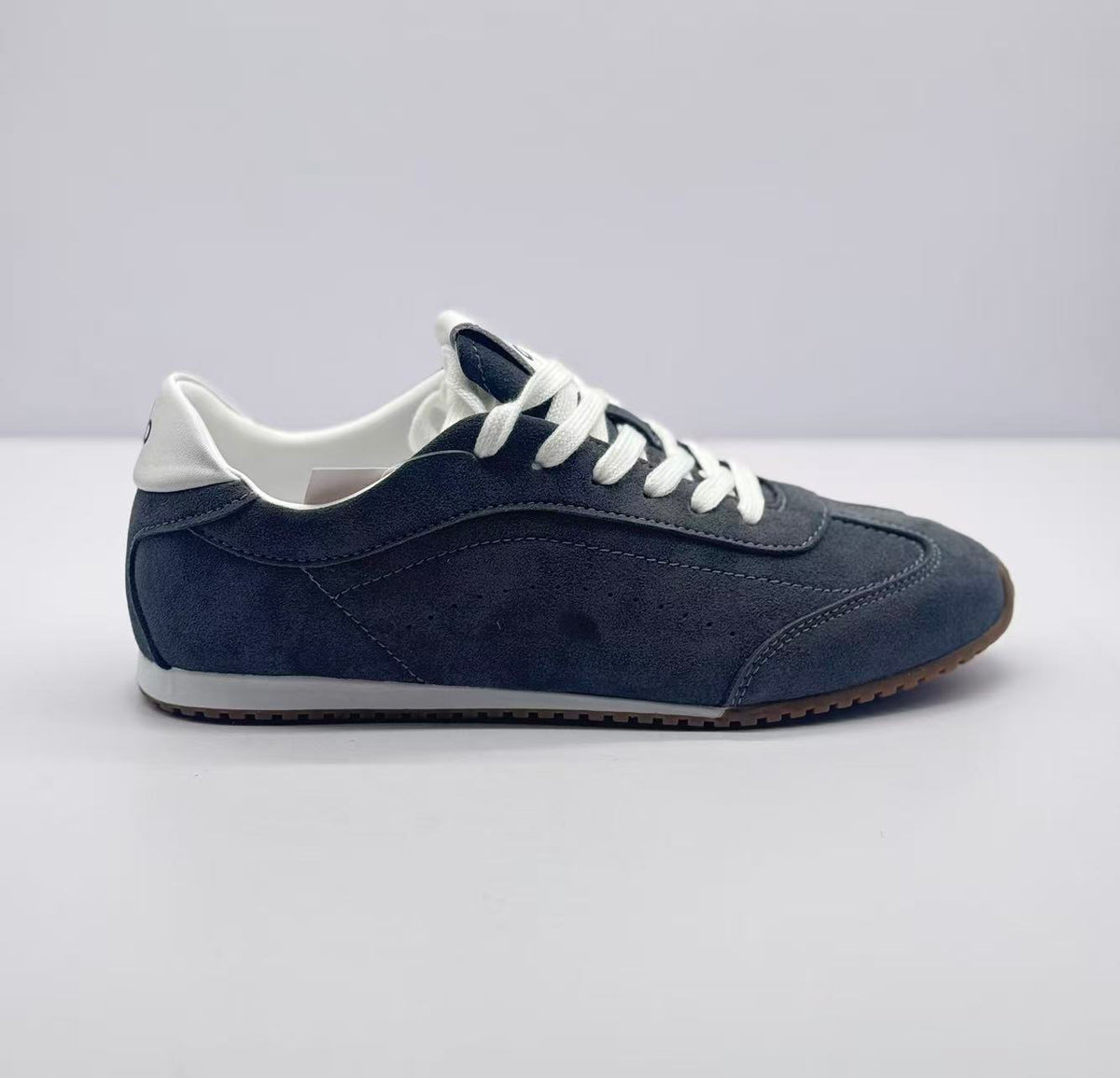 Side profile of carbon gray Alo low-top sneakers with white laces, white collar, and brown outsole.