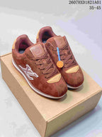 Pair of reddish-brown low-top sneakers with tonal laces and contrasting side emblems.