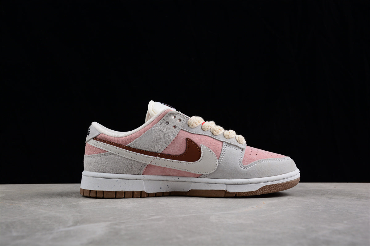 Side profile highlighting the pink and gray panels, layered Swoosh design, and low-top shape.