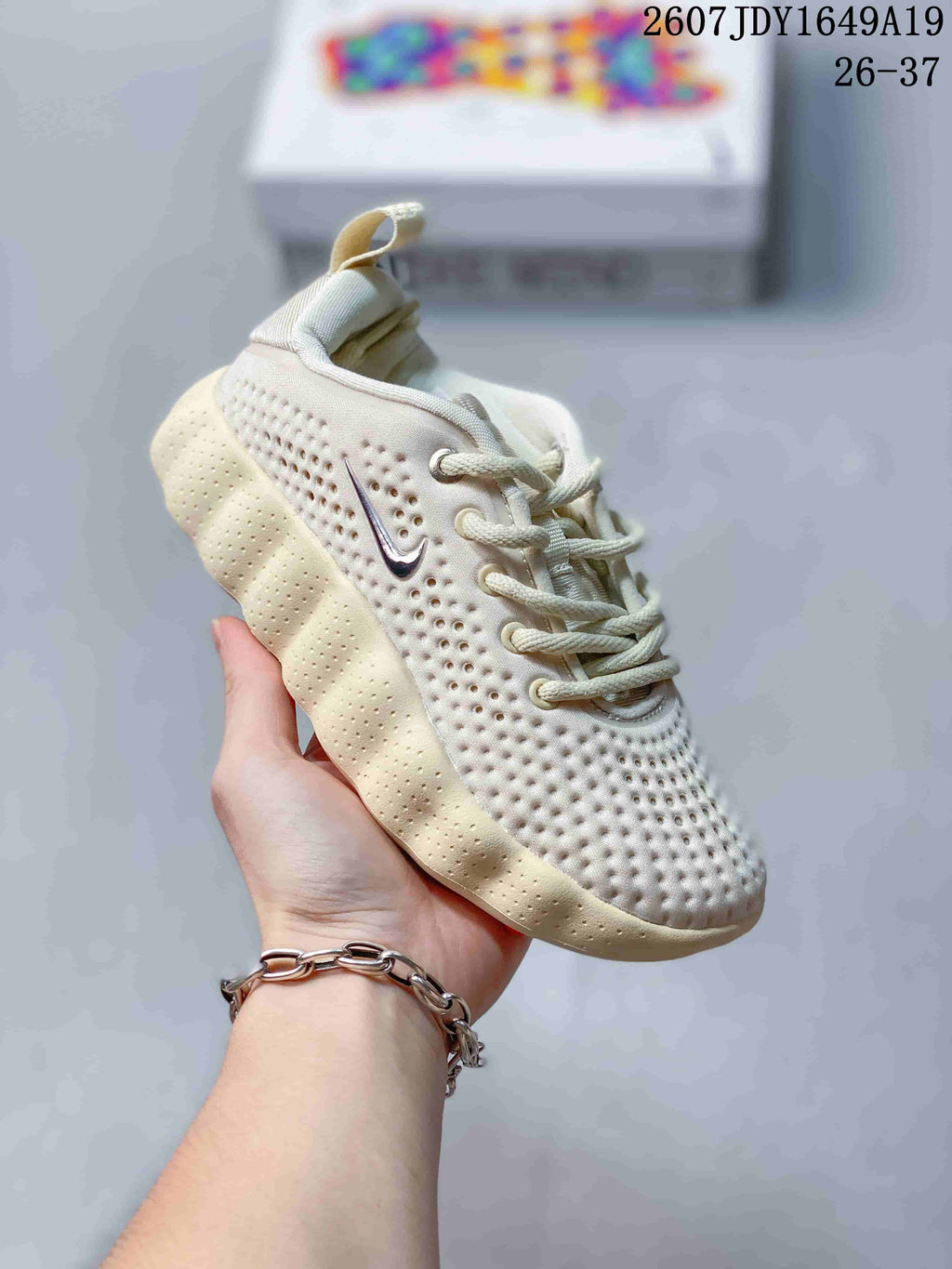 Cream and off-white Nike Mind 002 kids sneaker with matching laces and perforated details.