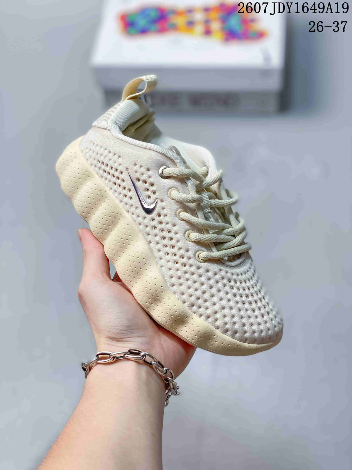 Cream and off-white Nike Mind 002 kids sneaker with matching laces and perforated details.