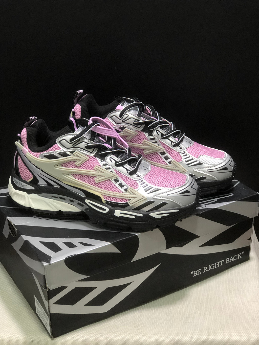 Three-quarter view of the sneakers on the box, whose side visibly reads “BE RIGHT BACK.”