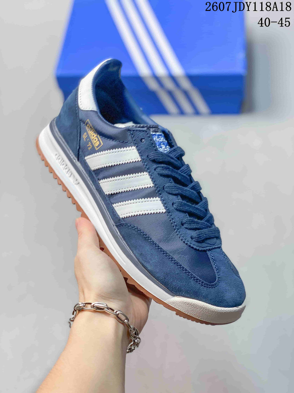 Angled side view showing the navy upper, white stripes, heel branding, white midsole, and gum outsole.