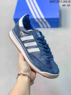 Angled side view showing the navy upper, white stripes, heel branding, white midsole, and gum outsole.