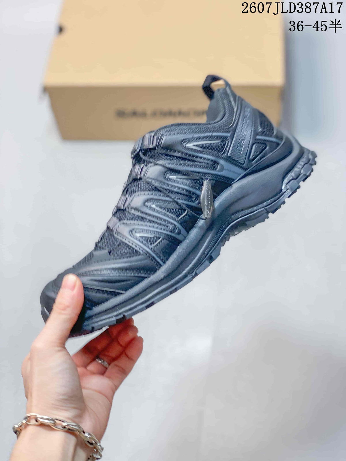 Side profile of the black Salomon XA PRO 3D shoe showing layered upper panels, lace hardware, heel structure, and lugged outsole.