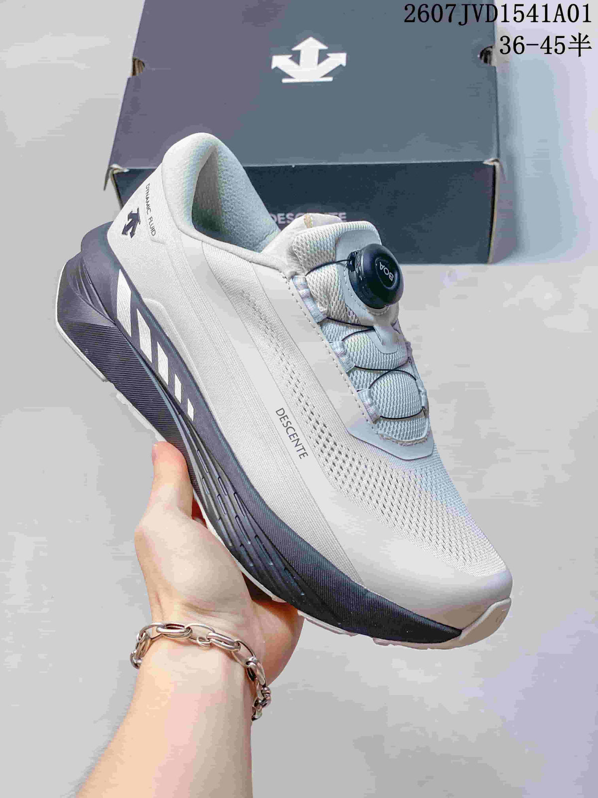 Side view of a white Descente running shoe with dark gray sole accents and dial closure.