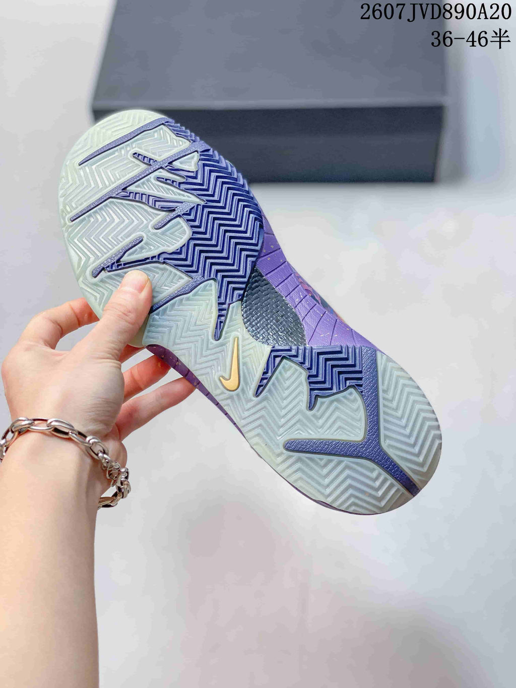 Close view of the patterned translucent outsole on a purple Nike basketball shoe.