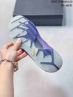 Close view of the patterned translucent outsole on a purple Nike basketball shoe.