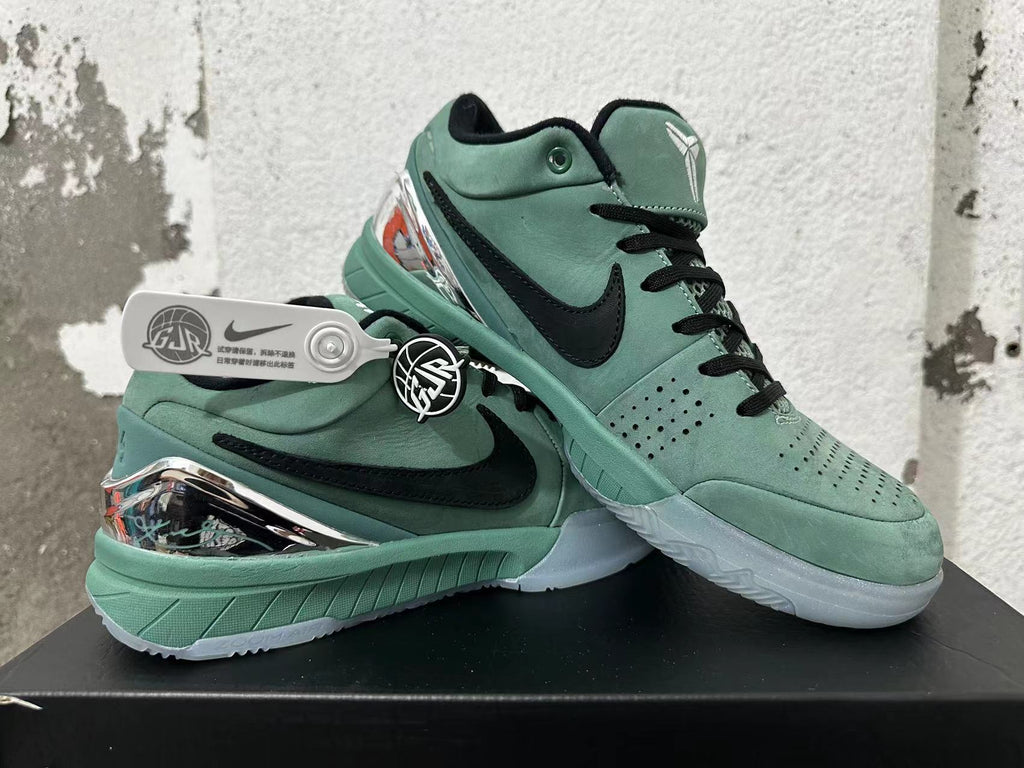 Pair of green Nike Kobe basketball shoes shown together, with black accents and reflective-looking heel details.