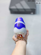 Rear view of a purple soccer cleat showing the white heel panel, padded collar, and molded studs.