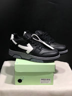Pair of black low-top sneakers with white arrow side details displayed on a light green shoe box; the box label shows size 41.