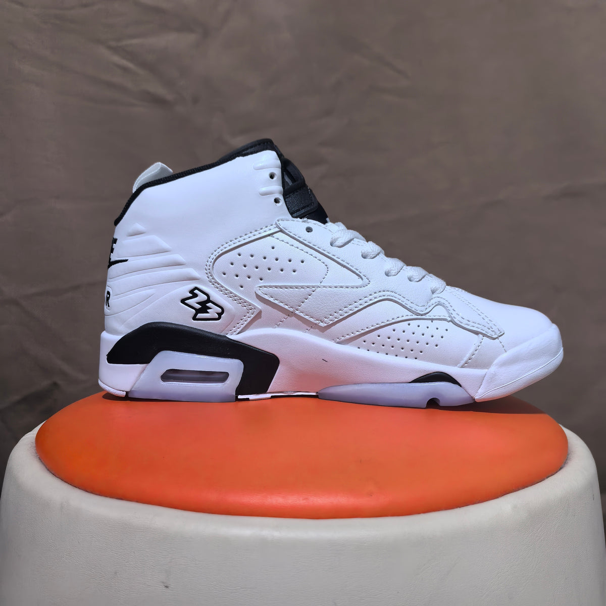 Side view of a white high-top sneaker with black trim, perforated panels, and heel window.