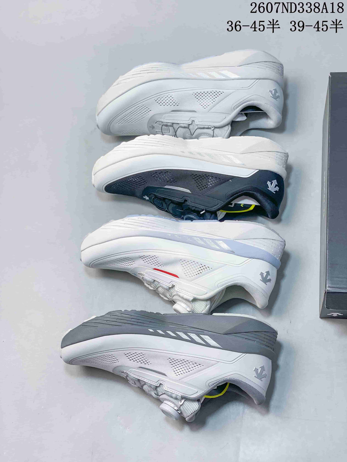 Multiple white and black Descente sneakers arranged side by side to show the available color variations and outsole profiles.