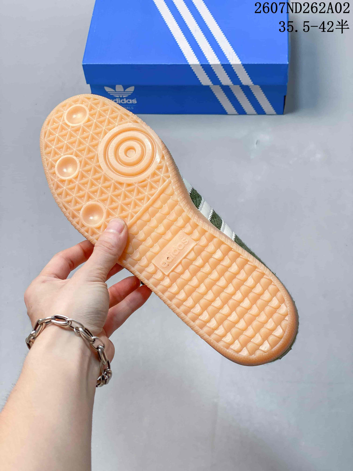 Underside view showing the textured gum-colored outsole of an olive-green sneaker