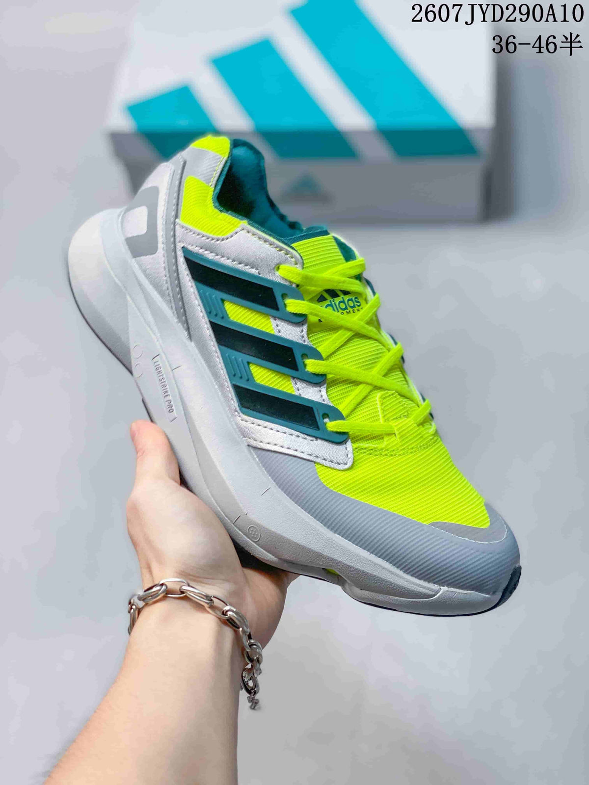 Side view of a gray and lime adidas Equipment Adios Pro sneaker showing layered side branding and a sculpted sole.