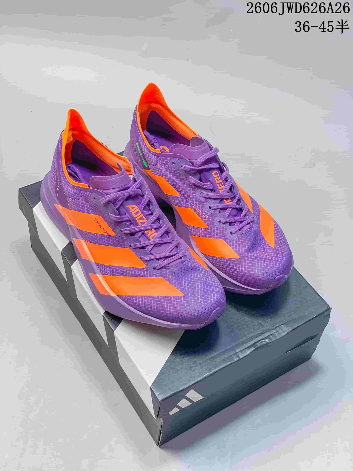 Purple and orange Adidas Adizero-style running shoes displayed on a shoebox.