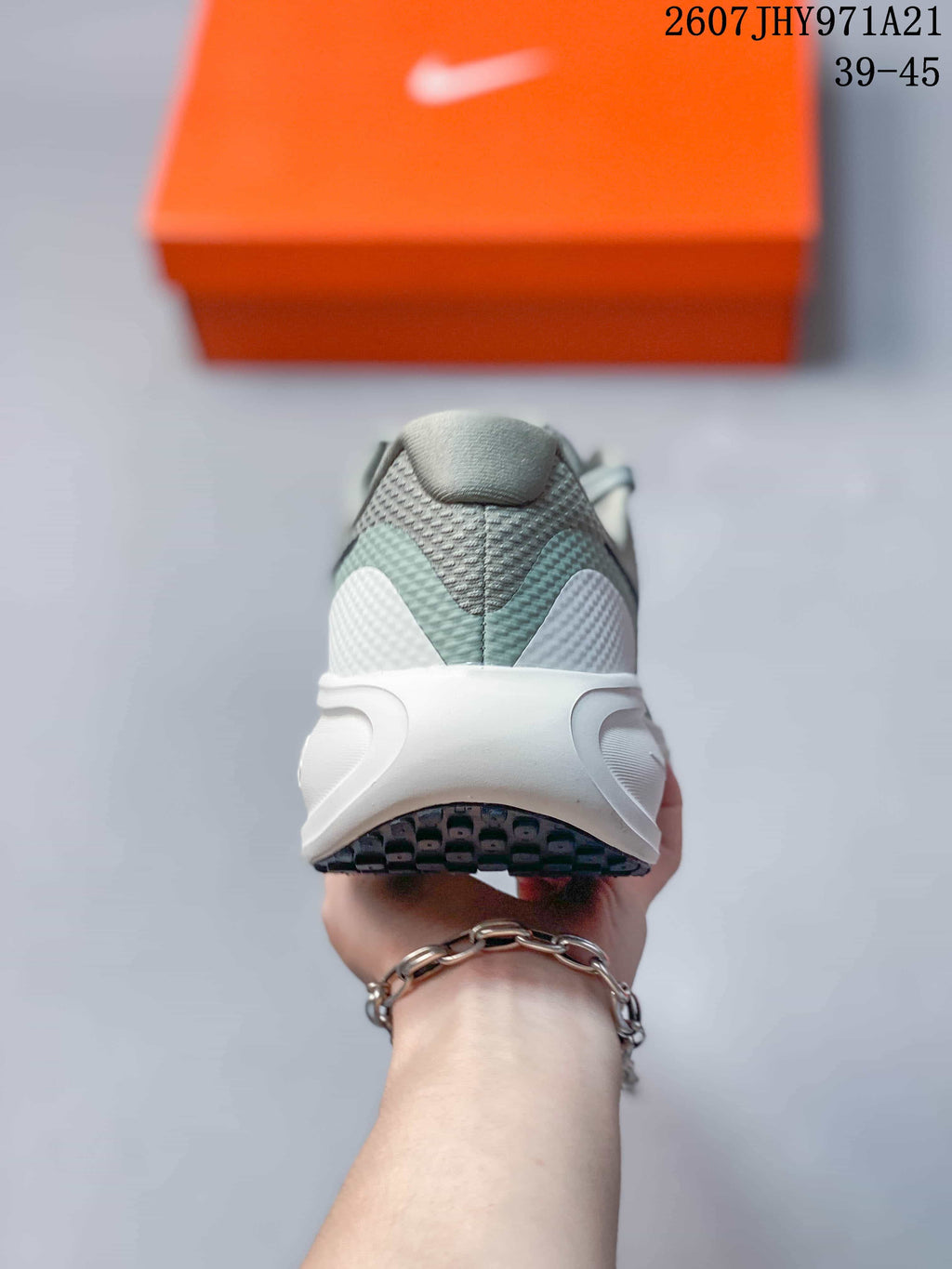 Rear view showing the padded heel, layered upper panels, white midsole, and outsole.
