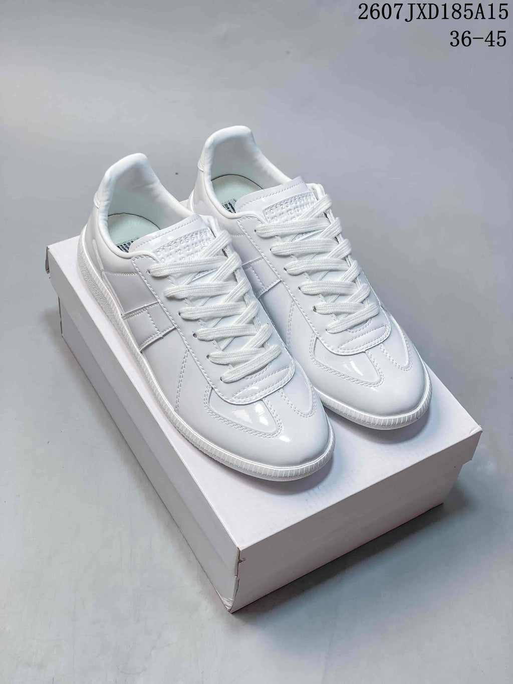 Pair of white Maison Margiela low-top sneakers displayed on a shoebox