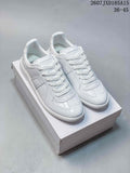 Pair of white Maison Margiela low-top sneakers displayed on a shoebox