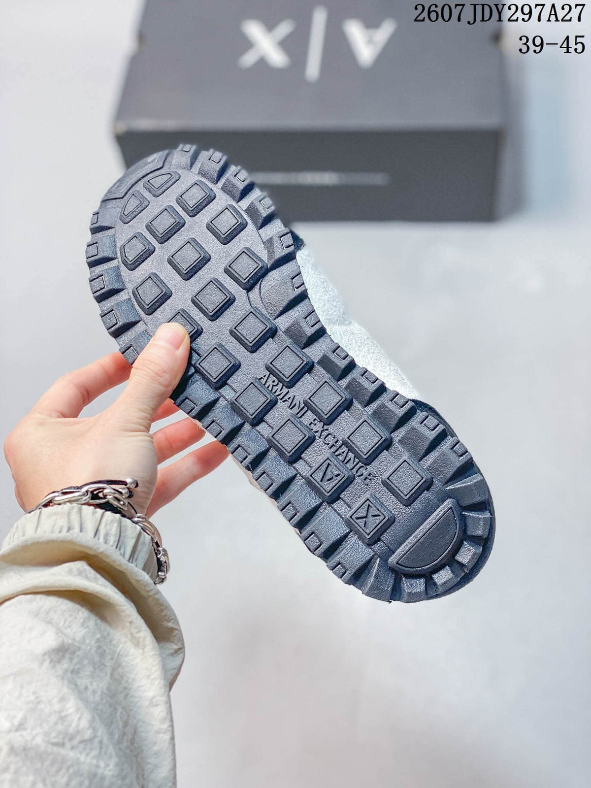 Close-up of the dark textured outsole with raised rectangular tread blocks and Armani Exchange branding.