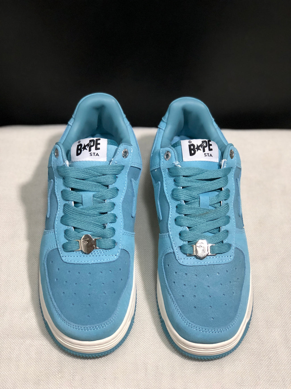 Front view of the pair showing the perforated light blue toe boxes, lace-up fastening, and tongue branding.