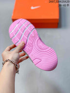 Underside view of the pink outsole showing segmented traction grooves and a patterned tread.