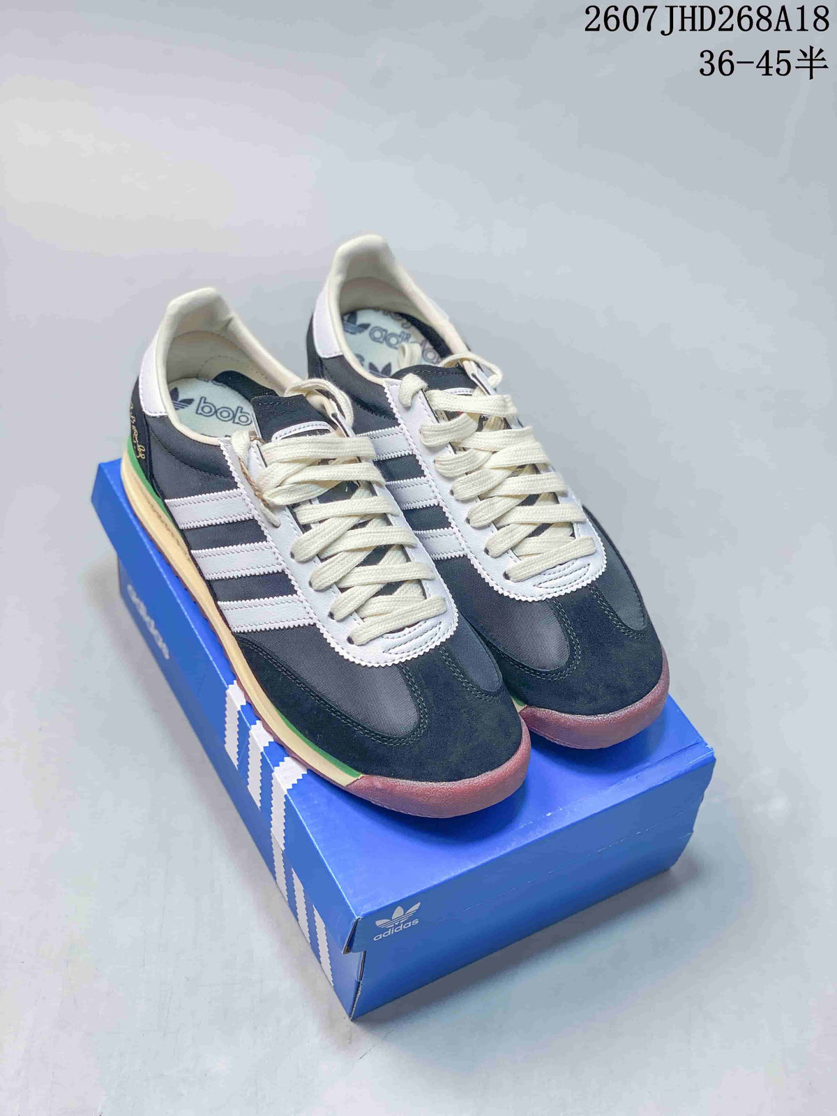 Pair of navy and white adidas SL 72 low-top sneakers displayed on an adidas shoebox.
