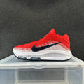 Side view of red, white and black Nike sneakers with a black Swoosh and white midsole