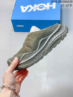 Side profile of an olive-toned mule sneaker with a textured upper