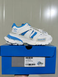 White and blue low-top sneaker displayed on a blue shoe box, with the box label showing Track Forum Low Top and sample size C 37.