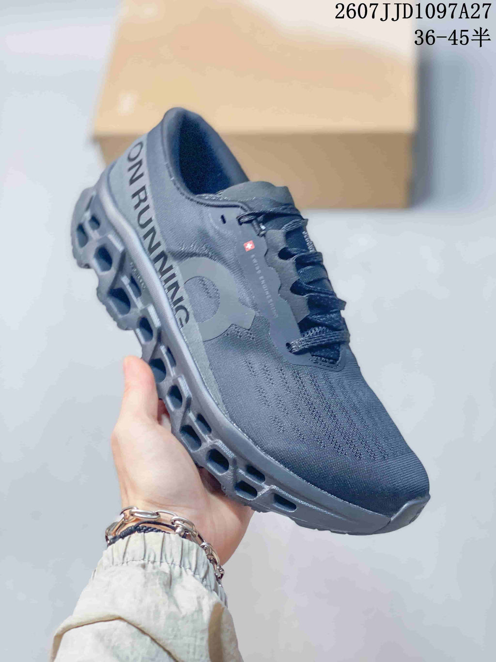 Angled side view of the dark gray On sneaker showing the heel branding, side logo, and sculpted outsole.