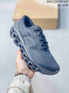 Angled side view of the dark gray On sneaker showing the heel branding, side logo, and sculpted outsole.