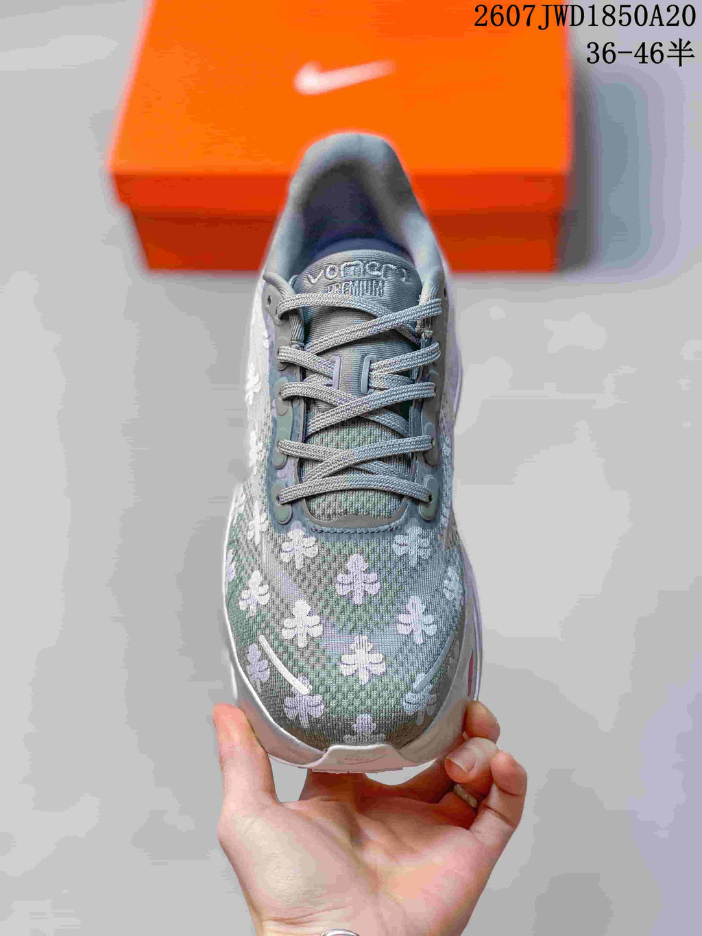Top view of the gray lace-up sneaker showing the floral upper, tongue branding, and rounded toe.
