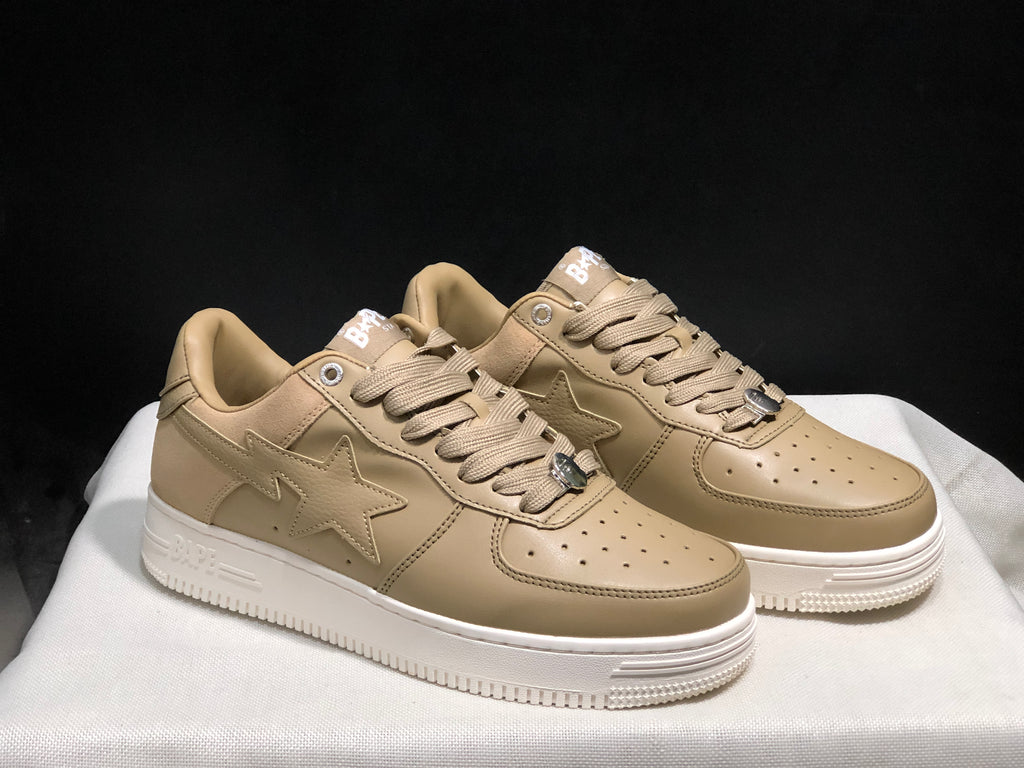 Three-quarter view of the pair showing the beige uppers, star-shaped side details and white soles.