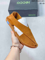 Close-up of a tan cross-strap shoe showing the open sides and stitched sole edge; image label shows style code 2607JYD601A01 and sizes 38–48.