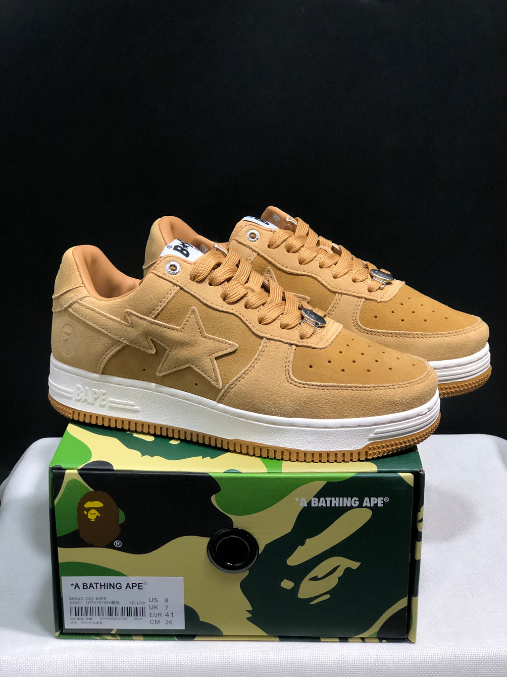 Pair of wheat Bape Sta low-top sneakers displayed on a BAPE camo shoebox; the label shows EU 41, US 8, UK 7 and CM 26 for the photographed sample.