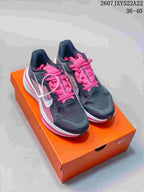 Pair of black and pink low-top sneakers displayed on an orange shoebox.